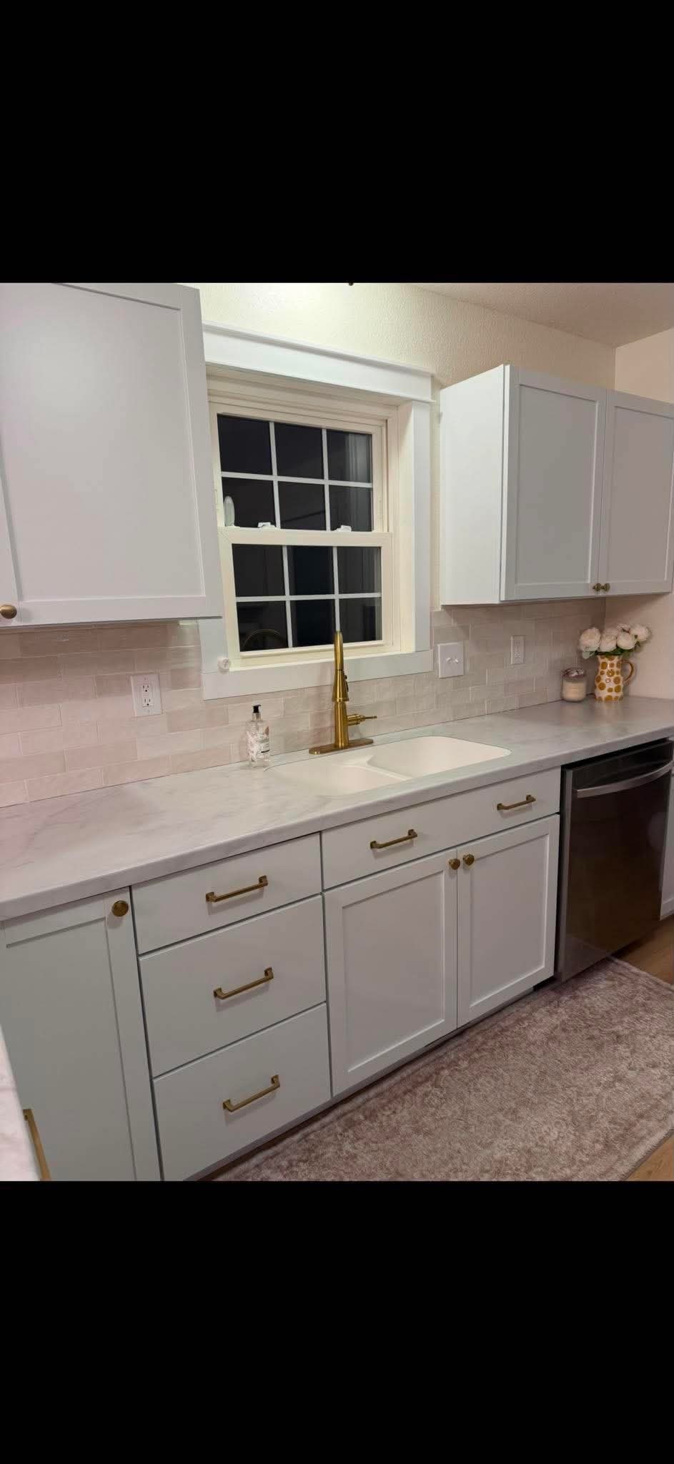 White shaker kitchen with gold fixtures and marble counters