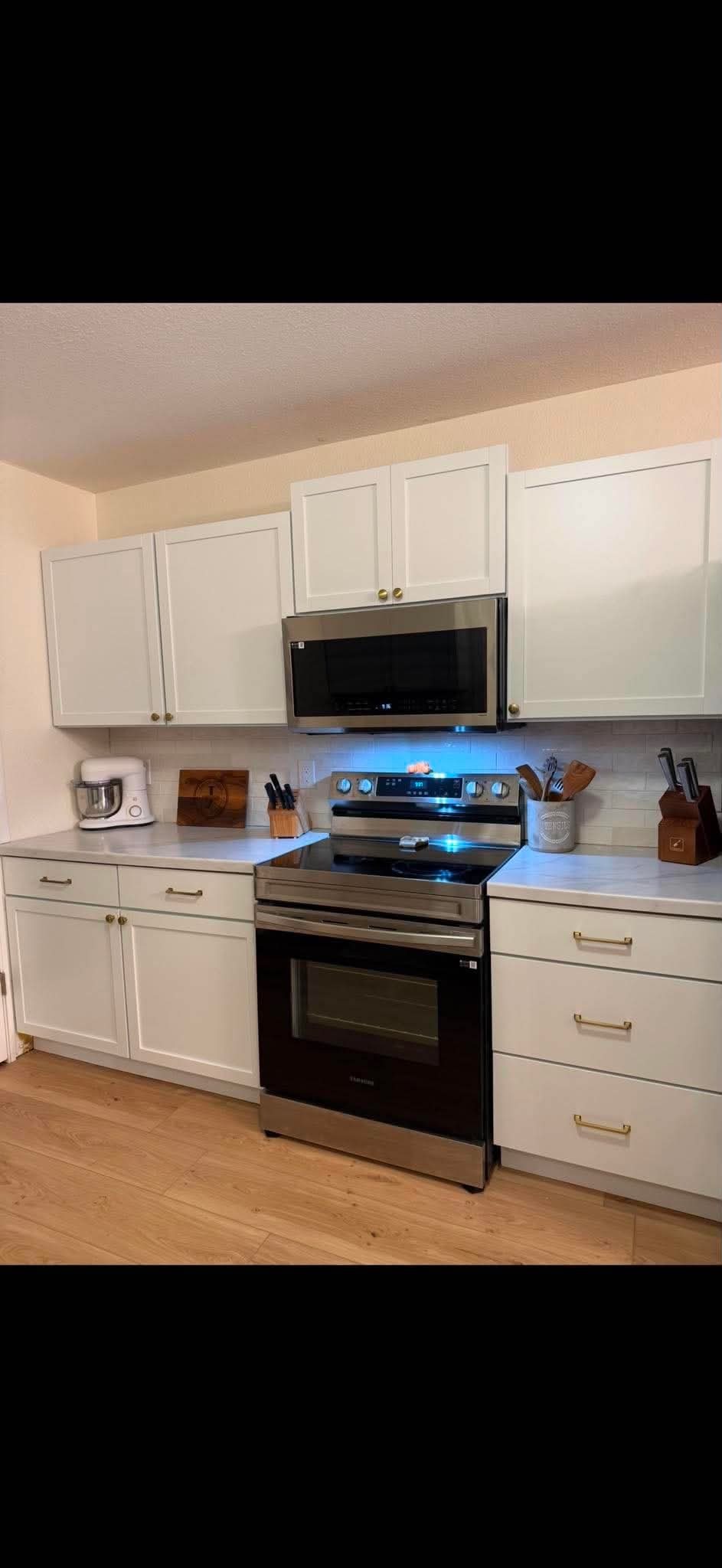 White kitchen with stainless range and subway backsplash